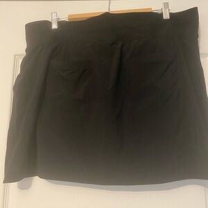 Black Mini Skort with zippered front pockets and back pockets.